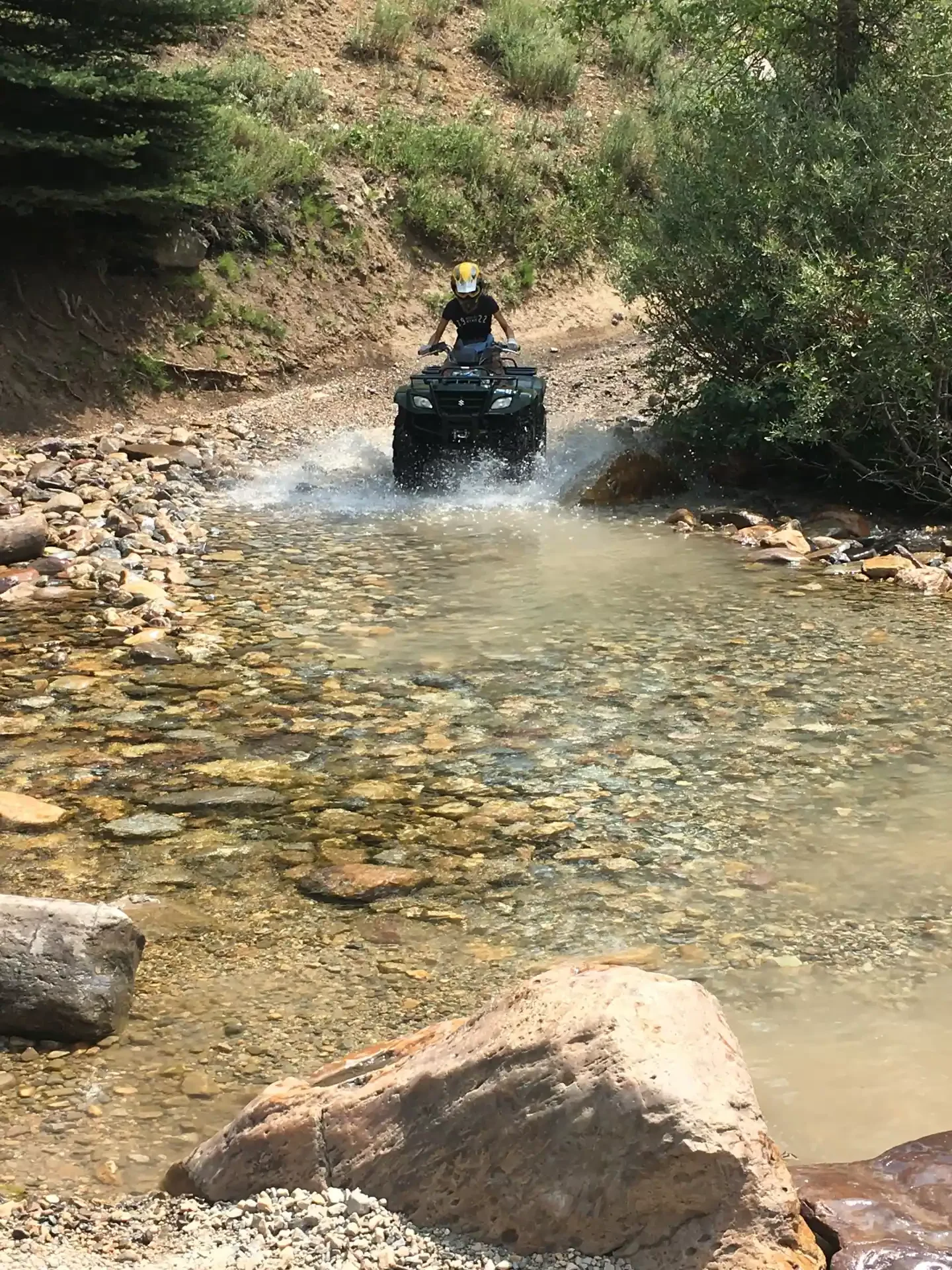 ATV rider crossing a stream in Island Park backcountry