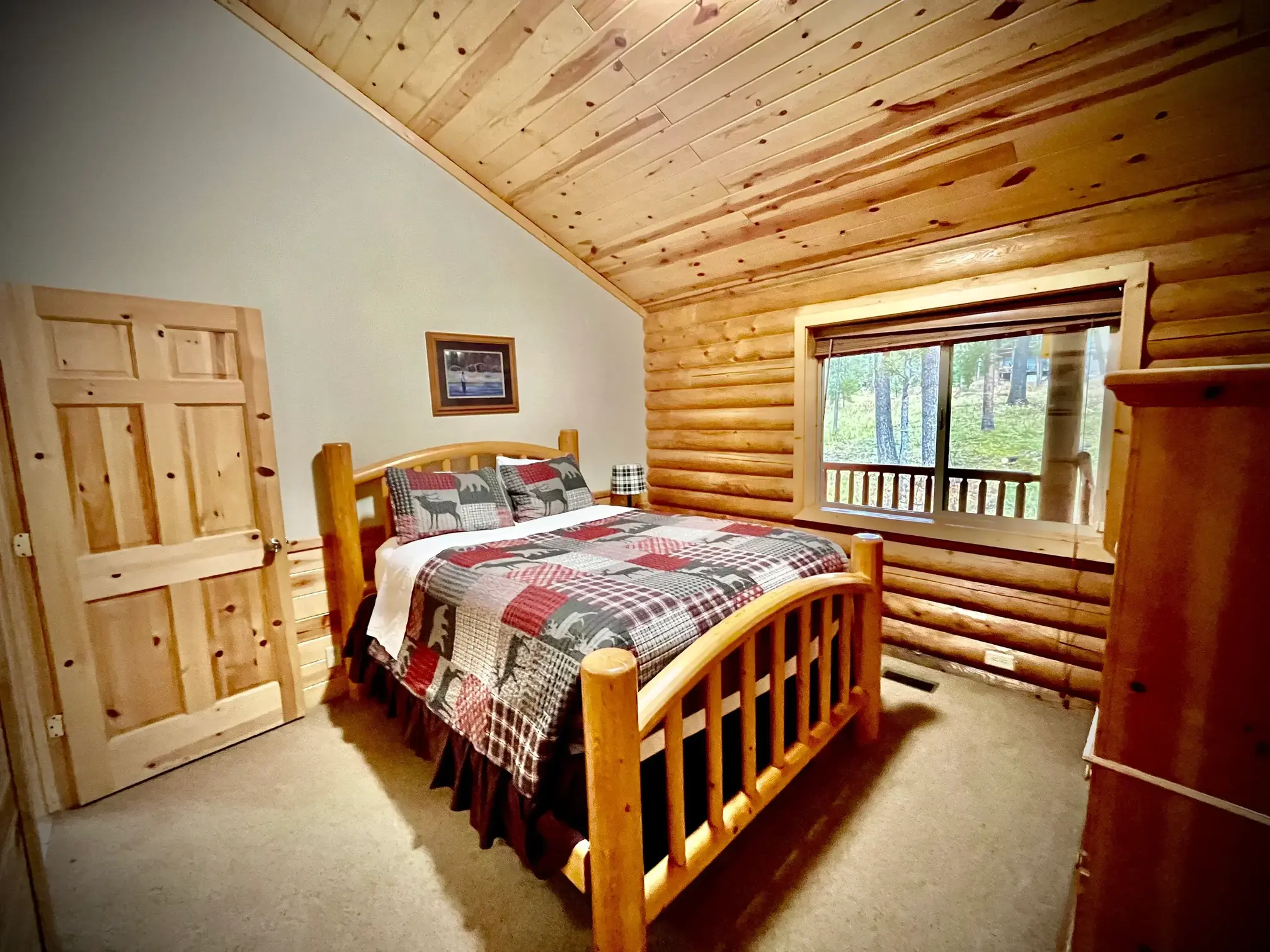 Fish-themed room with a rustic log queen bed, dresser, and luggage rack