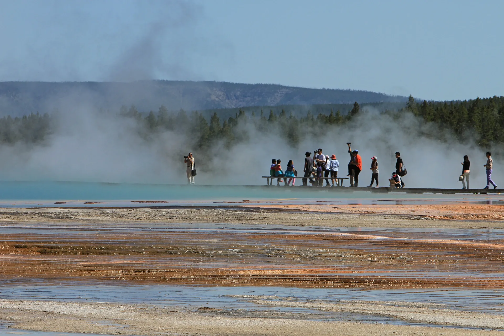 Visitors walking on the boardwalk at Grand Prismatic Spring in Yellowstone