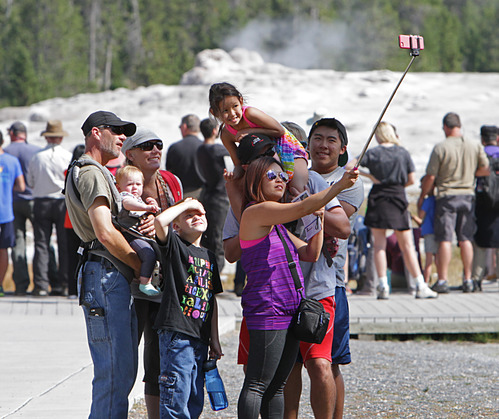 Visitors taking photos at Old Faithful in Yellowstone National Park